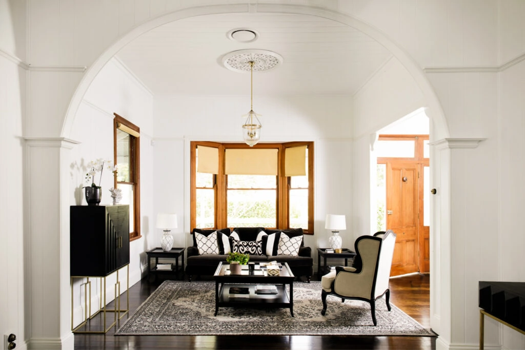 A stylish living room in a traditional home, with comfortable seating and wooden furniture.