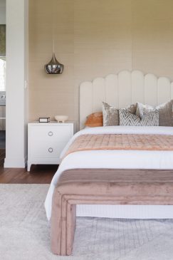 Modern bedroom with an ensuite, styled with a white aesthetic and accents of orange and neutral tones