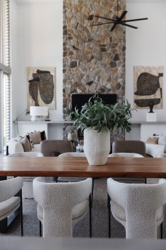 Living, dining area with high ceilings and a atone affect fireplace