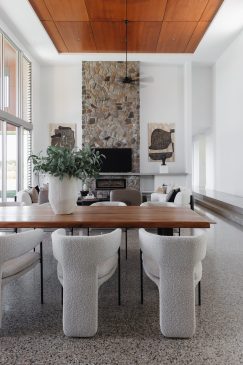 Open plan dining and living room with high ceilings, bold art and large plant pot and plant